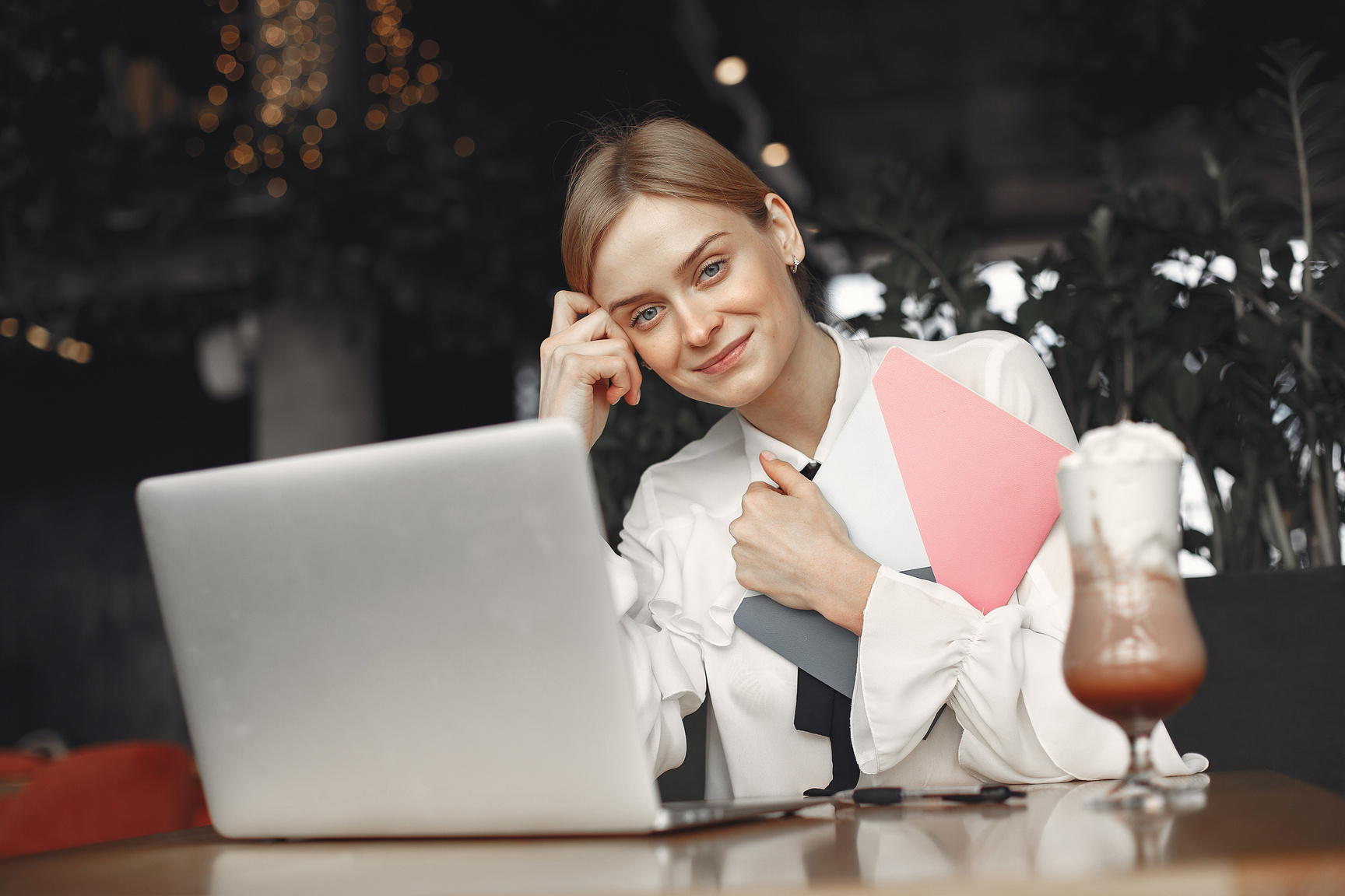 Positive businesswoman working on laptop in restaurant